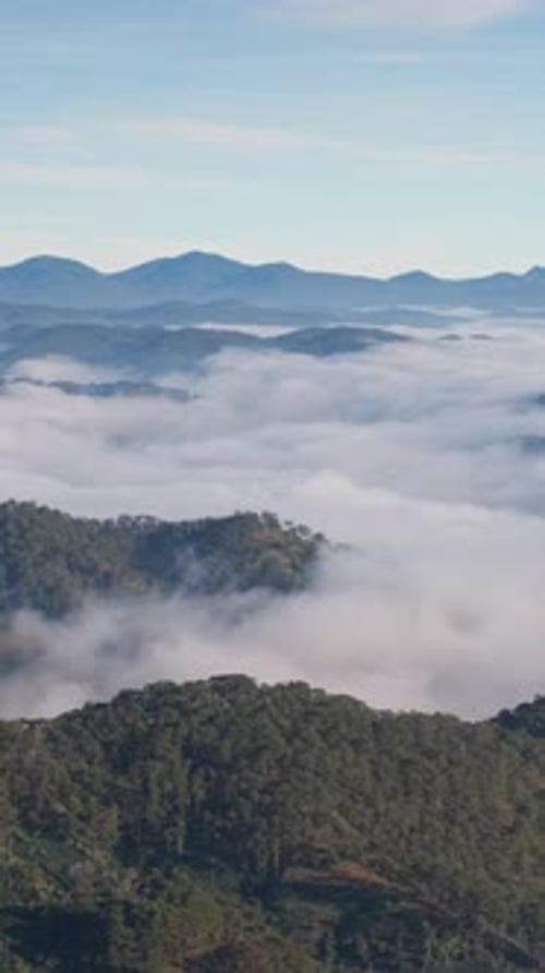 Paysage de vallée brumeuse et de montagnes, de nuages, de mer