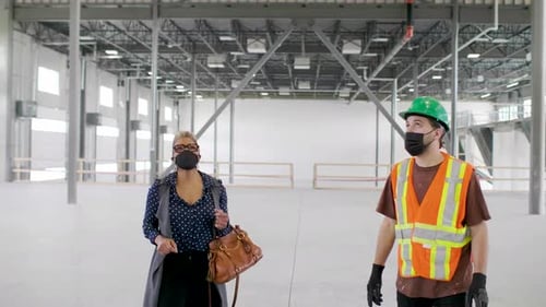 Woman and Man Discuss Construction in Empty Building