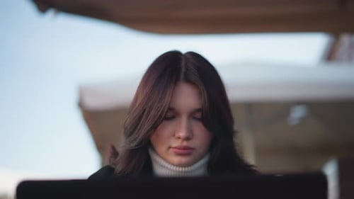 Lady Seated Sober with Hair Swaying in Gentle Wind Outdoors