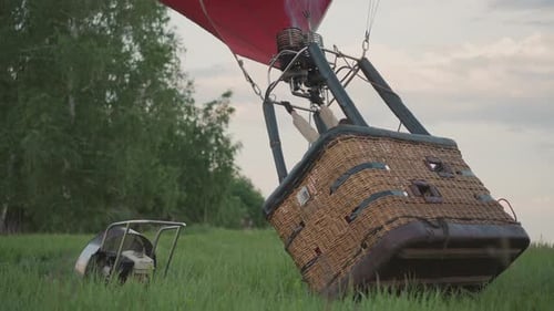 Pilot Operating Burner to Lift Hot Air Balloon Basket in Field