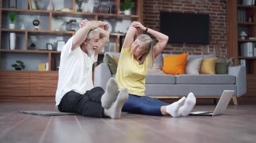 Senior Couple Stretching and Exercising Together at Home