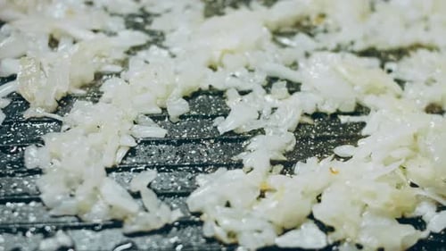 Chopped White Onion Sizzling in Pan