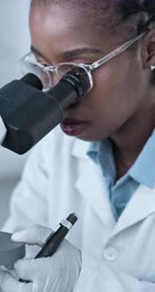 Woman Working in a Laboratory Using Microscope