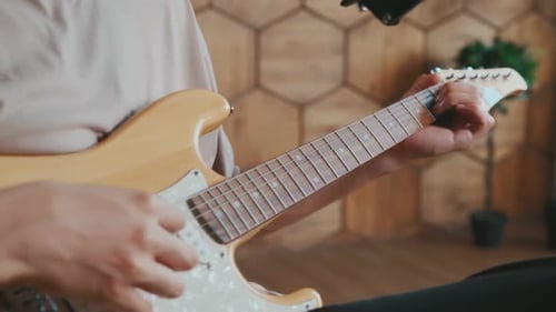 Musician Practicing Guitar and Composing New Music