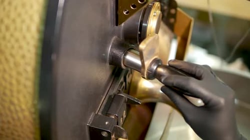 Gloved Hand Adding Coffee Beans to Roaster Machine