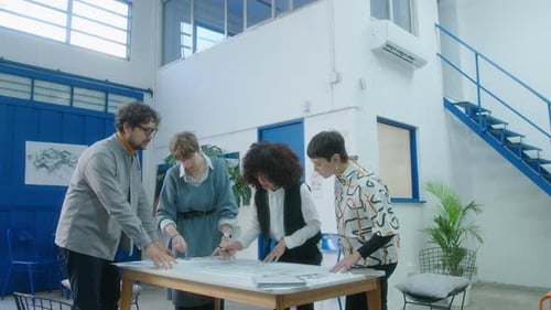 Team of Architects Discussing Floor Plans in the Office