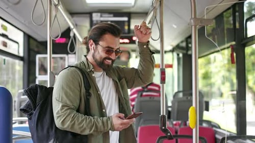 Man Uses Cell Phone on Public Bus