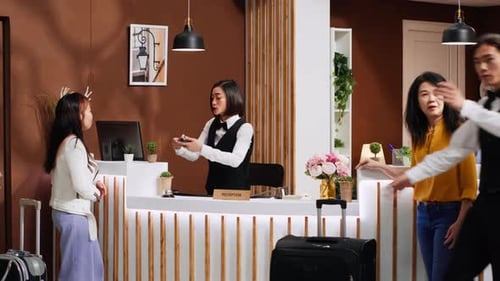 Asian Traveler Paying for Hotel Room During Check in Process