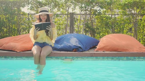 Woman Reading a Book by the Pool