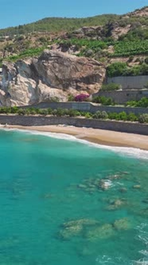 Vertical Video Aerial Views of the Azure Sea Meet the Rugged Beauty of Rocky Beaches and Coastal