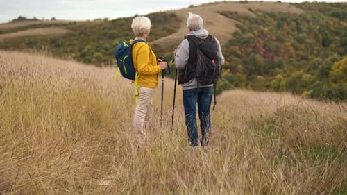 Active Mature Couple Hiking on Grassy Hillside