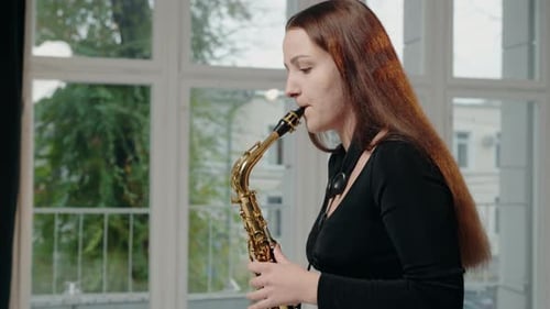 Woman Plays Saxophone in Bright Studio