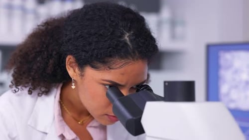 Woman Scientist Using Microscope in Laboratory Setting