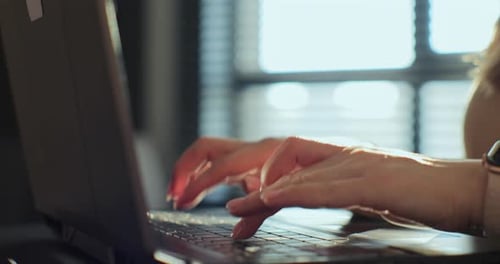 Woman's Hands Typing on a Laptop Keyboard