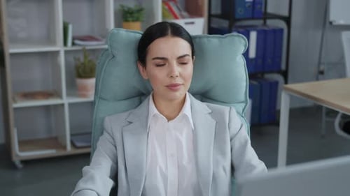 Footage of Tired Beautiful Brunette Young Woman Laying at Comfortable Office Armchair Relaxing While