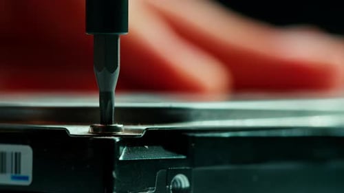 Technician Tightening Screw on Hard Drive with Screwdriver
