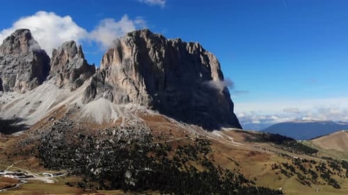 4K drone shot flying through mountains revealing massive dolomite mountain range in Italy. Beautiful