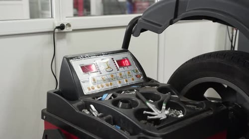 Mechanic Using Wheel Balancing Machine in Auto Garage