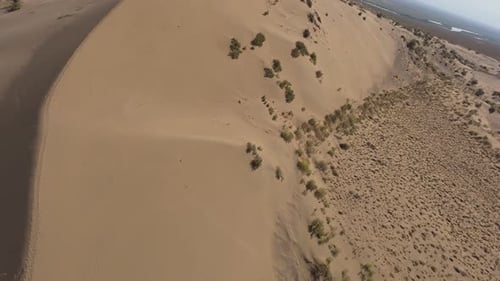 Hikers Exploring Majestic Sand Dunes in Desert Landscape