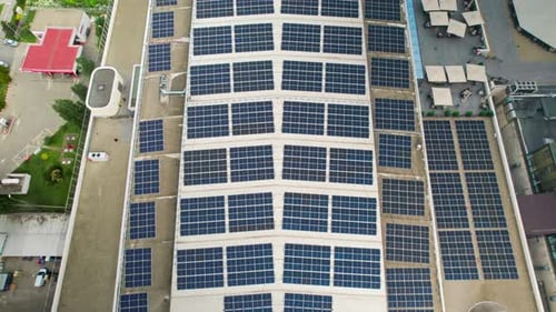 Aerial drone view of a building with fully covered roof with solar panels