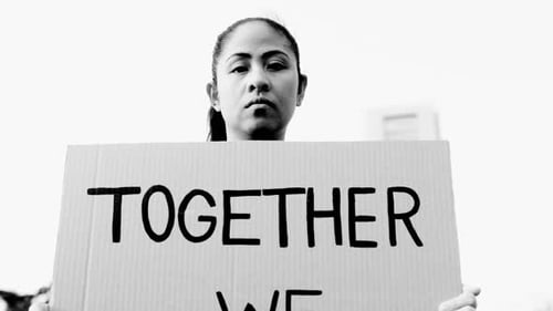 Woman rights. Asian activist holding banner at demonstration in road city. Black and white editing
