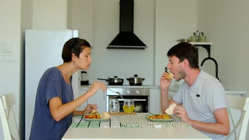 Couple Enjoying Lunch Together in Bright Modern Kitchen