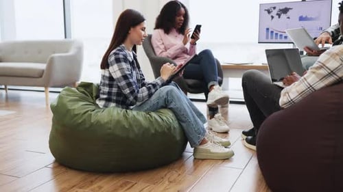 Diverse Coworkers Collaborating in Office Workspace with Relaxed Environment