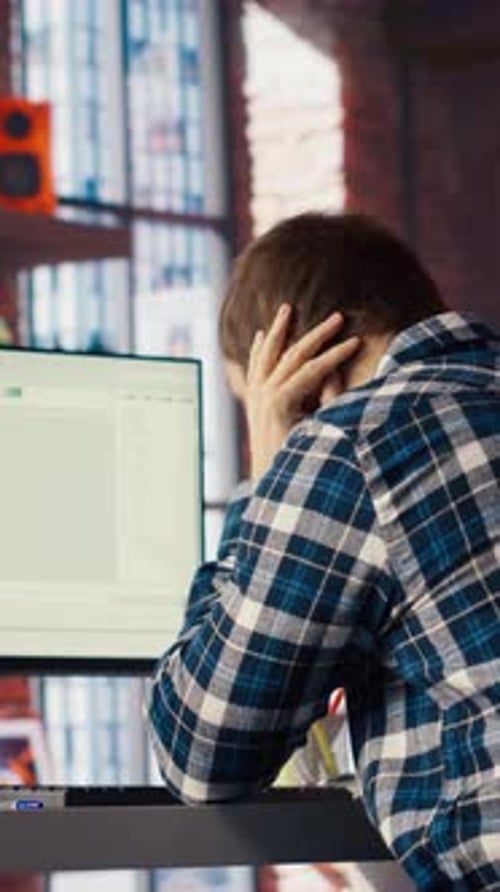 Desarrollador de software en una computadora esperando a que el Código termine de compilar Yawning