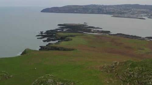 Ireland's Eye island cliffs revealed as seagulls glide in cinematic aerial
