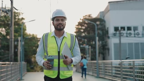 Portrait of Engineer with Laptop and Coffee Cup Walking to Construction Site