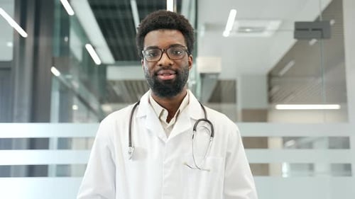 Portrait of professional African American doctor smiling confidently in modern medical office
