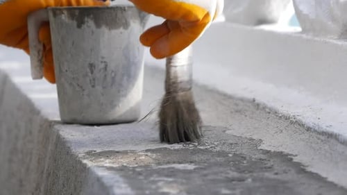Applying Grey Sealant to Concrete Structure