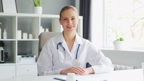 Doctor Works in the Medical Office Woman in White Coat Workplace of a Professional Female Therapist