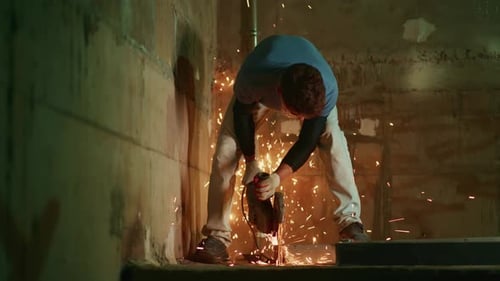 Sparks Fly As Worker Cuts Metal Focused Worker Cuts Metal in Narrow Stairwell with Sparks