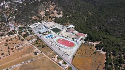 Aerial drone footage of a sports stadium the village of Sant Antoni on the island of Ibiza in Spain
