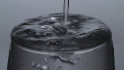 Close Up Of Drinking Water Being Poured Into A Glass On The Light White Screen Background
