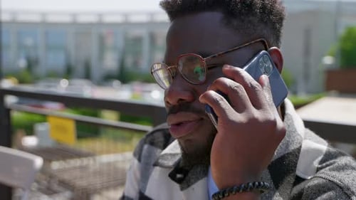 Black Man Having a Phone Conversation Outdoors in the City
