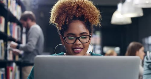 4k video of a student using her laptop in the college library