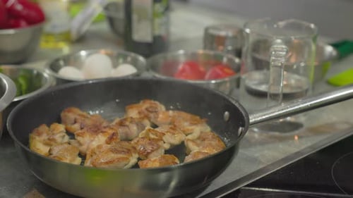 Fry pieces of meat in a frying pan. Frying chicken hot oil in frying pan, close-up.