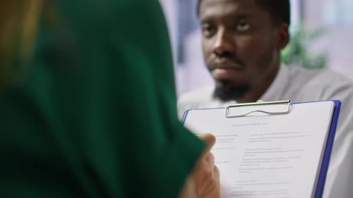 Coworkers review employment documents in office