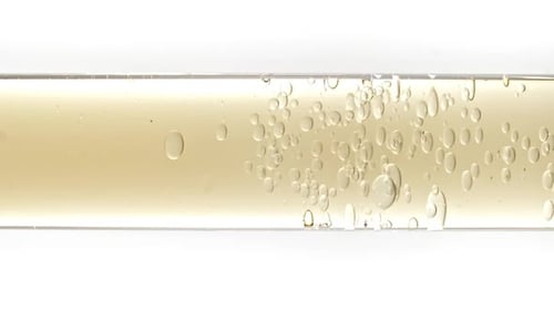 Golden Liquid with Bubbles Rising in a Test Tube
