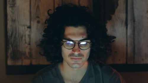 Serious Man Home Office in Night Work Meeting