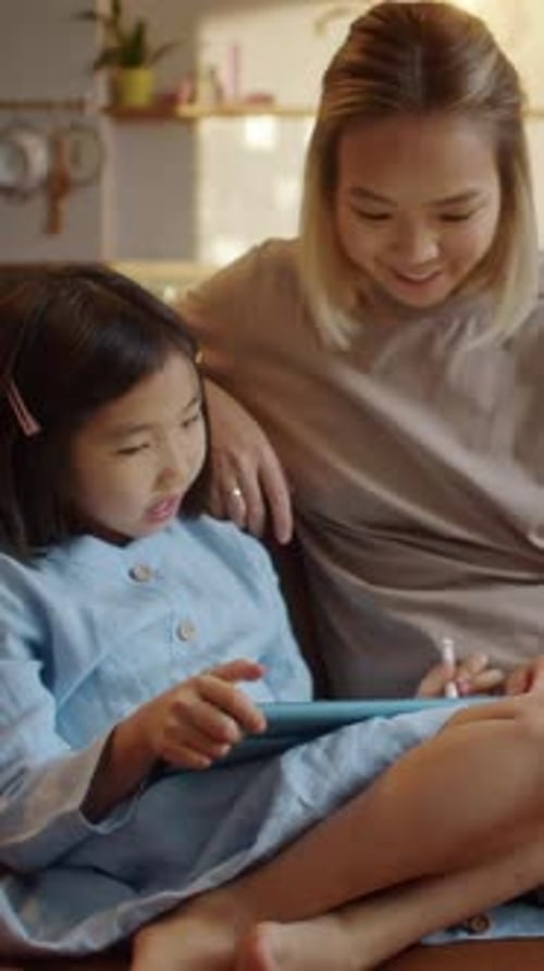 Girl and Young Woman Using Tablet Indoors at Home