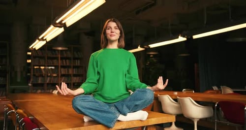 Woman Practicing Yoga on Conference Table Indoors