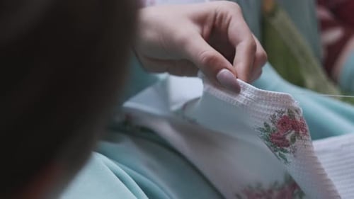 Woman Carefully Embroidering Decorative Floral Pattern