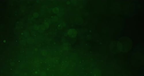 Glittering Particles Against Green Bokeh Circles