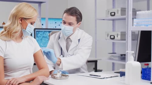 Doctor Giving Shot to Patient in Clinic