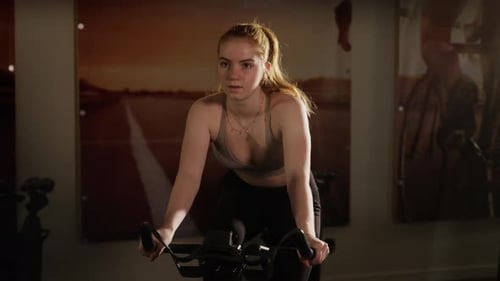 Fit Woman Cycling On Exercise Bike In Gym