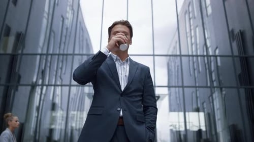 Portrait Smiling Businessman Drinking Coffee Standing at Glass Office Building. Handsome Successful