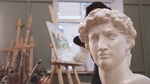 A Statue of a Man with a Hat On Capturing the Essence of a Young Woman Painter Artist in Studio